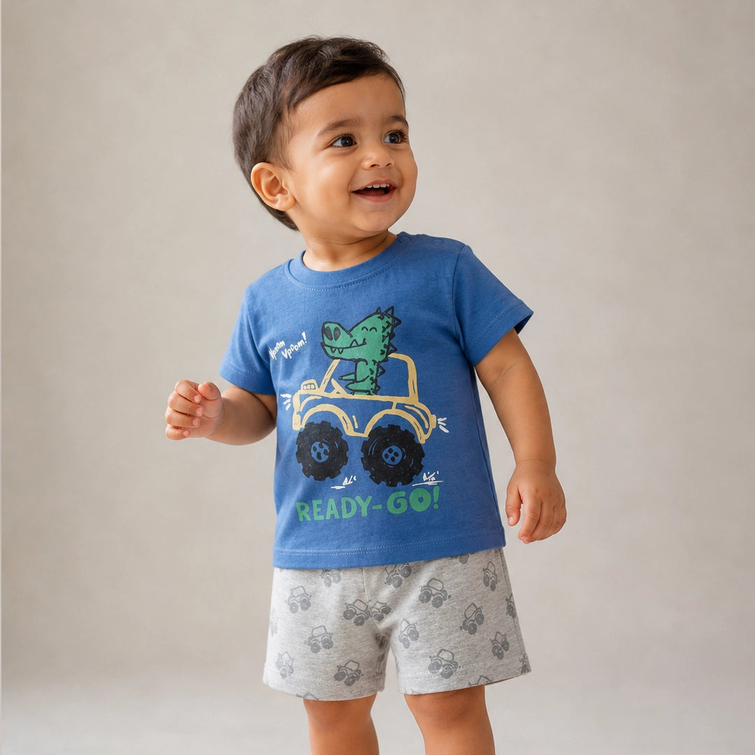 Child wearing a blue t-shirt with a dinosaur graphic and text, standing against a plain background