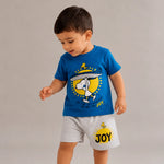 Child wearing a blue t-shirt and gray shorts with a 'JOY' design on a plain background