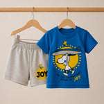 Children's blue t-shirt and gray shorts with a cartoon design and 'JOY' text on a beige background.