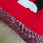 Close-up of a red, black, and white patterned fabric on a fluffy white background
