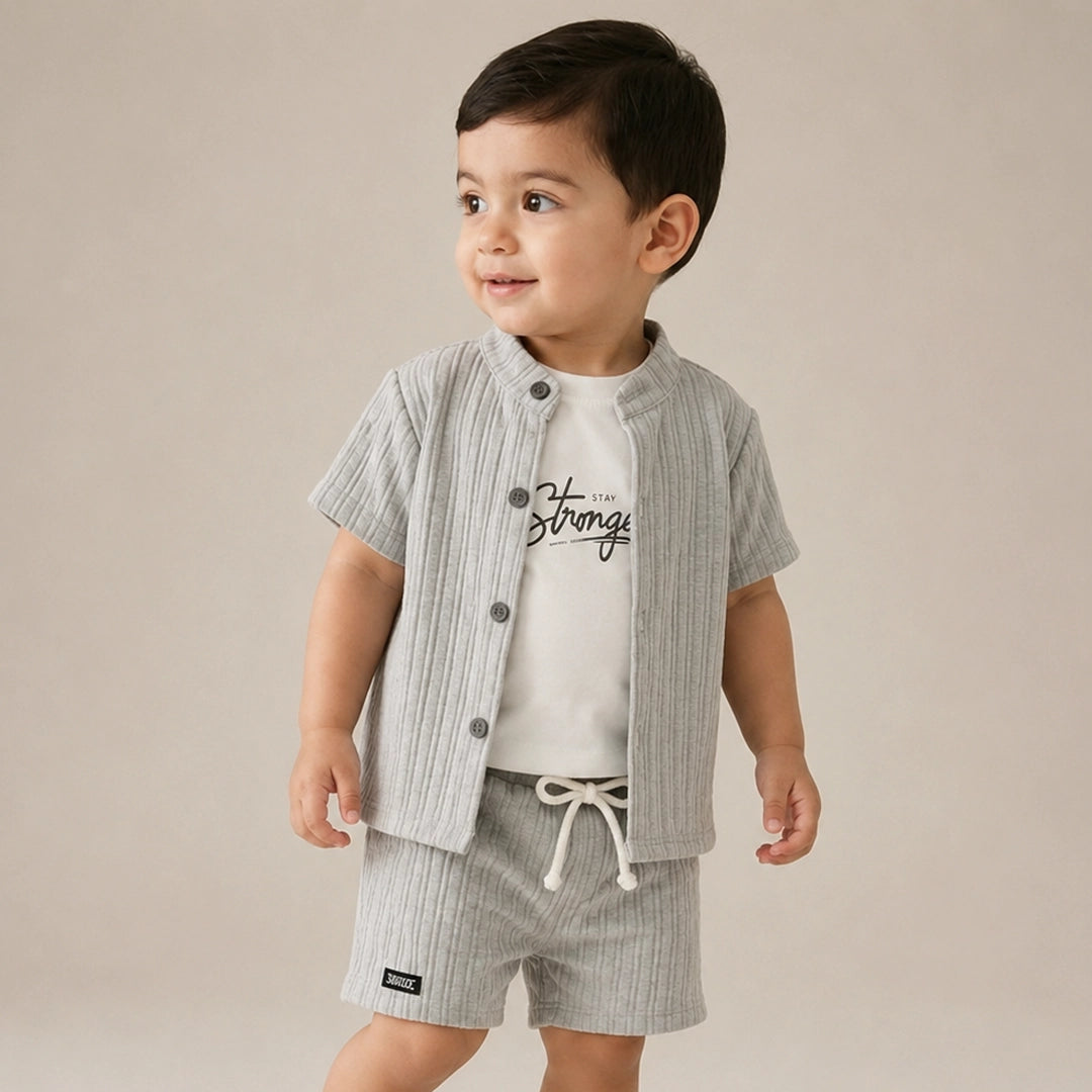 Child wearing a striped shirt and shorts set with a plain background